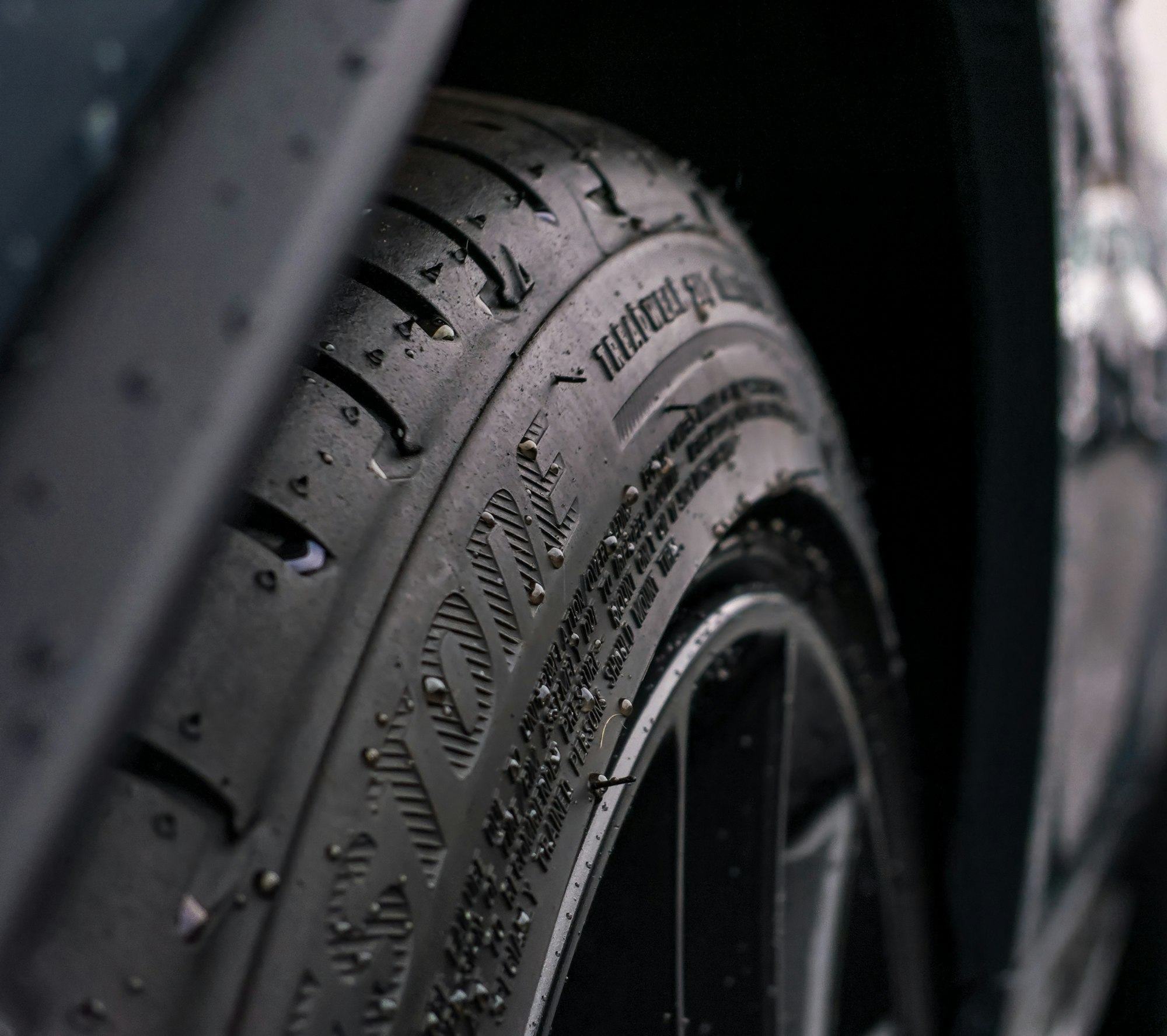 Close-up van een band op een donkere sportauto